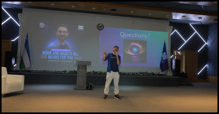 Person giving a presentation on stage with large screens